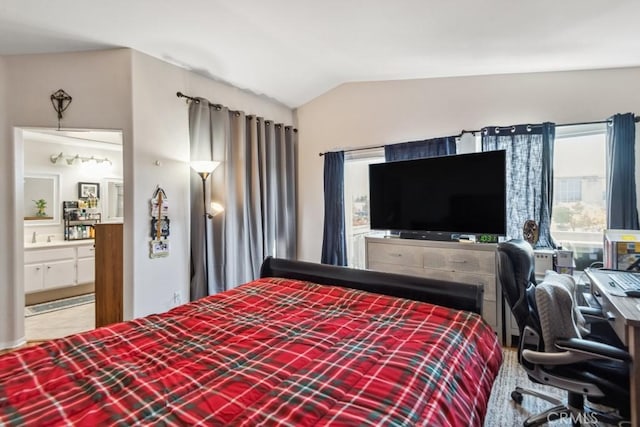 bedroom featuring lofted ceiling and ensuite bathroom