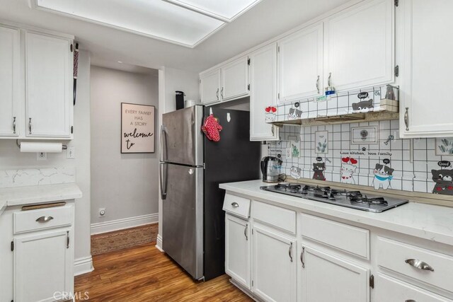 kitchen featuring white cabinetry, stainless steel appliances, and hardwood / wood-style floors