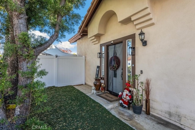 view of exterior entry with a yard