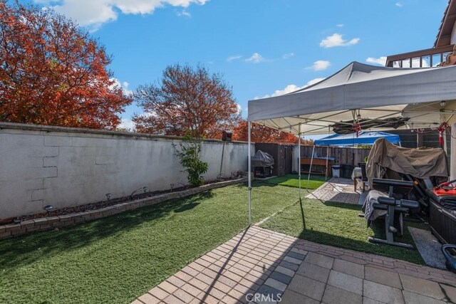 view of yard with a trampoline and a patio