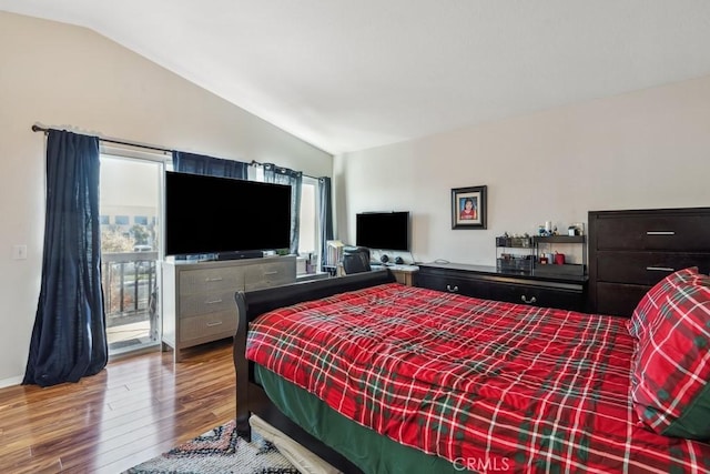 bedroom featuring lofted ceiling, access to exterior, and hardwood / wood-style floors