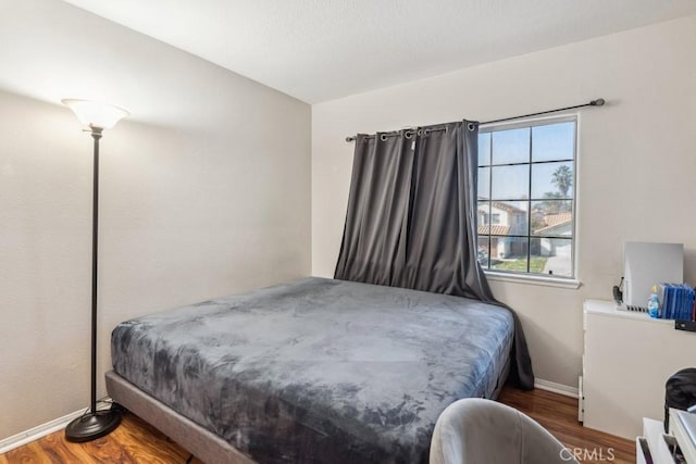 bedroom with dark wood-type flooring