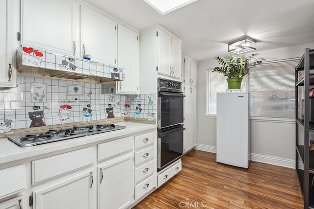 kitchen featuring stainless steel gas cooktop, double oven, decorative backsplash, and white cabinetry