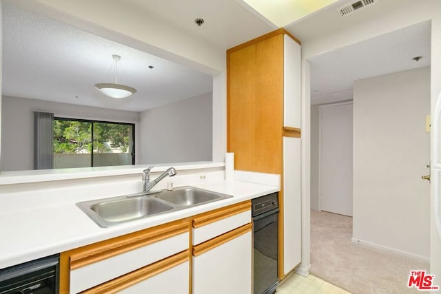 kitchen with dishwasher, white cabinetry, and sink