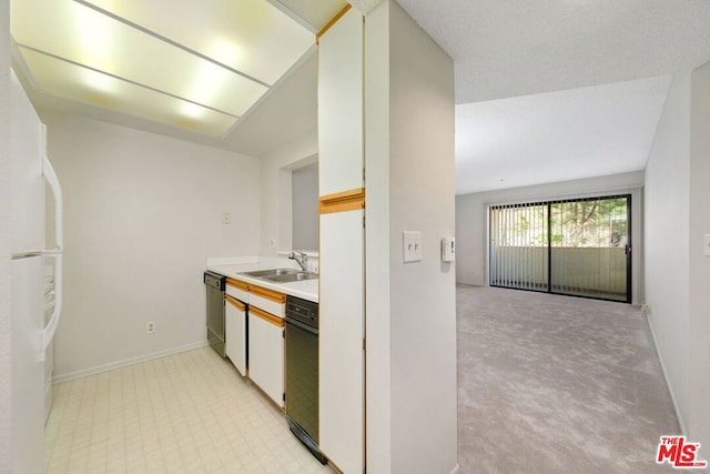 kitchen featuring sink, stainless steel dishwasher, white fridge, light colored carpet, and white cabinets