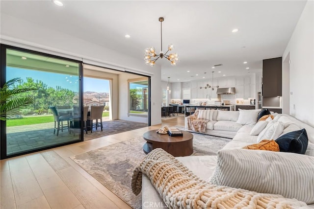 living room with a chandelier and light wood-type flooring