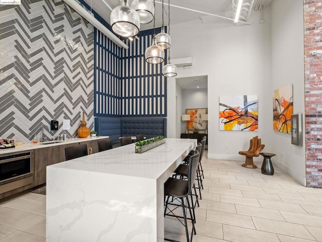 kitchen with light stone counters, a kitchen island, pendant lighting, light tile patterned floors, and oven