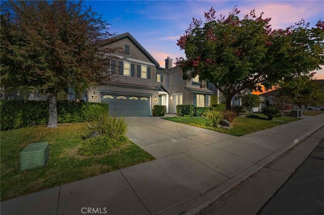 view of front of property with a garage and a lawn