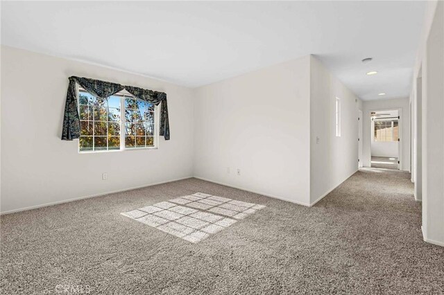 carpeted spare room featuring a healthy amount of sunlight