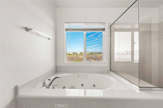 bathroom with a relaxing tiled tub