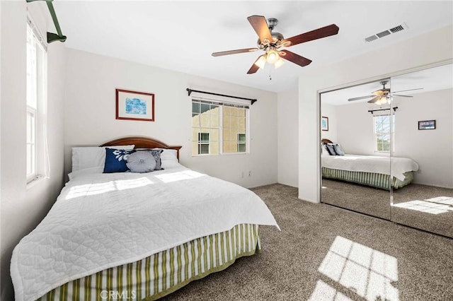 carpeted bedroom with ceiling fan and a closet