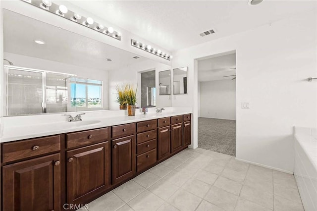 bathroom with tile patterned flooring, vanity, a shower with door, and ceiling fan