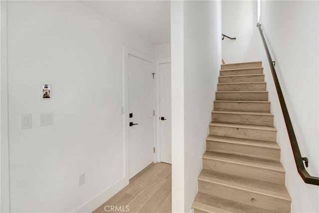 stairway with hardwood / wood-style floors