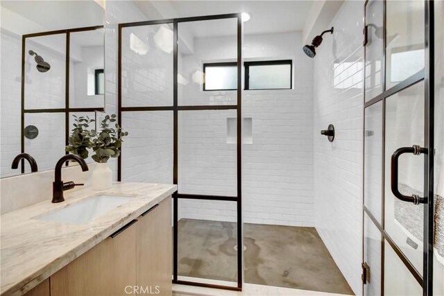 bathroom featuring a wealth of natural light, vanity, and walk in shower