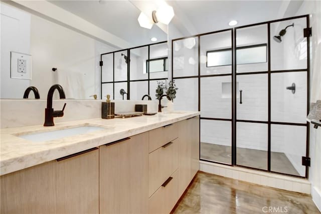 bathroom featuring a shower with door and vanity