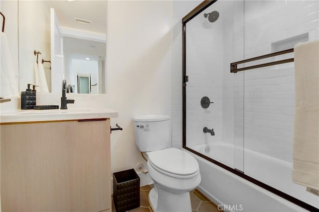 full bathroom with tile patterned flooring, vanity, bath / shower combo with glass door, and toilet