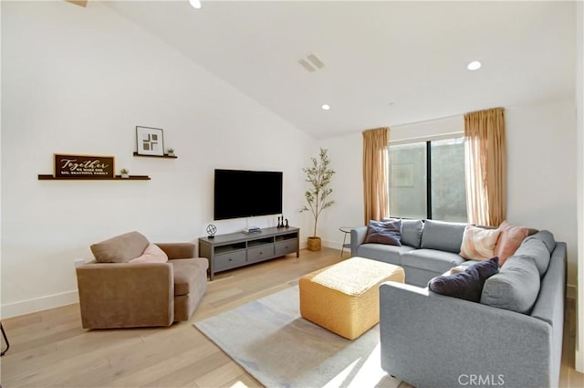 living room with high vaulted ceiling and light hardwood / wood-style floors