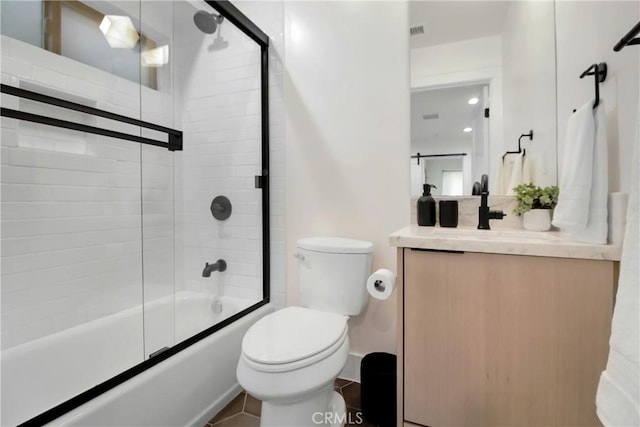 full bathroom with tile patterned flooring, vanity, toilet, and enclosed tub / shower combo