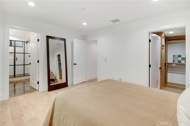 bedroom featuring light wood-type flooring and connected bathroom