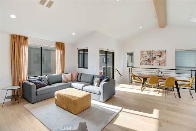 living room with vaulted ceiling with beams and light hardwood / wood-style flooring