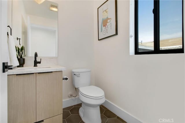 bathroom featuring tile patterned flooring, vanity, and toilet