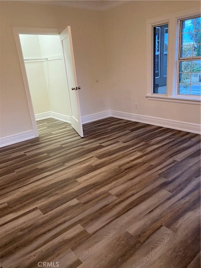 unfurnished bedroom with a closet and dark hardwood / wood-style floors