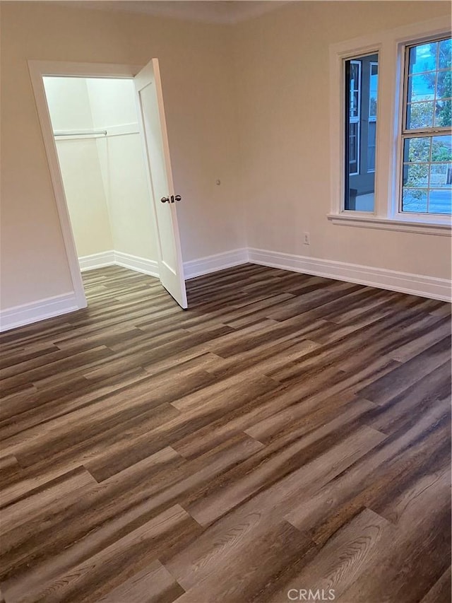 unfurnished bedroom featuring a closet and dark hardwood / wood-style flooring