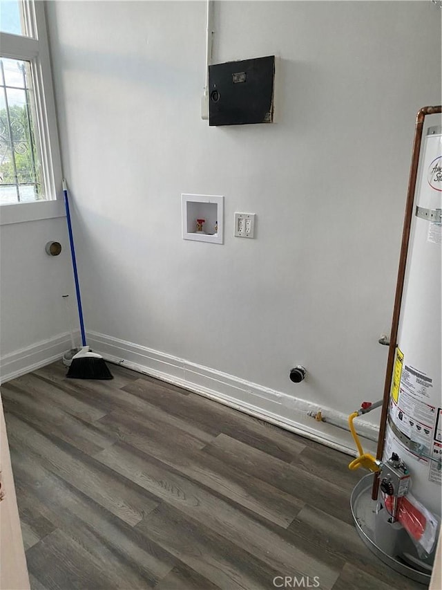 washroom with water heater, dark hardwood / wood-style flooring, and hookup for a washing machine