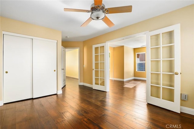 unfurnished bedroom featuring a closet, dark wood-type flooring, french doors, and ceiling fan