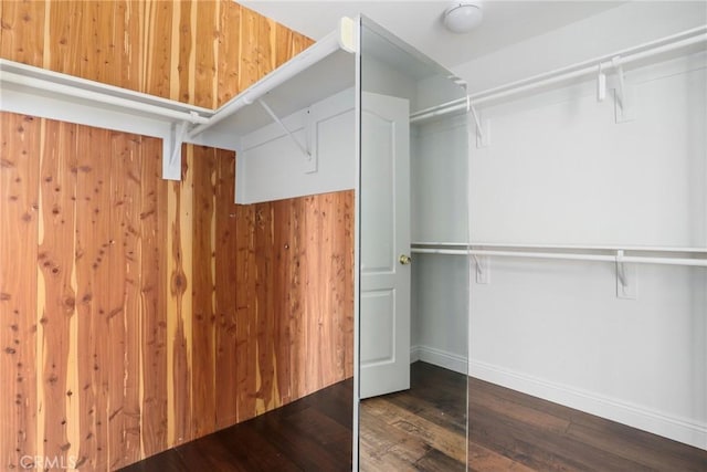 walk in closet with dark wood-type flooring