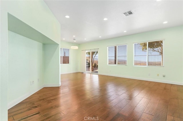 spare room featuring hardwood / wood-style flooring and plenty of natural light