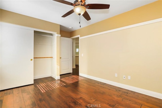 unfurnished bedroom with dark hardwood / wood-style flooring, a closet, and ceiling fan