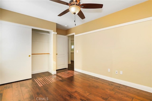 unfurnished bedroom featuring dark wood-type flooring, a closet, and ceiling fan