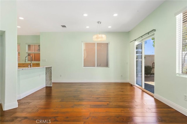 unfurnished living room with sink and dark wood-type flooring