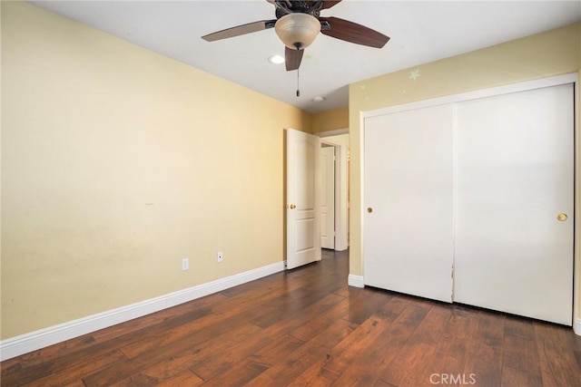 unfurnished bedroom with ceiling fan, dark hardwood / wood-style flooring, and a closet