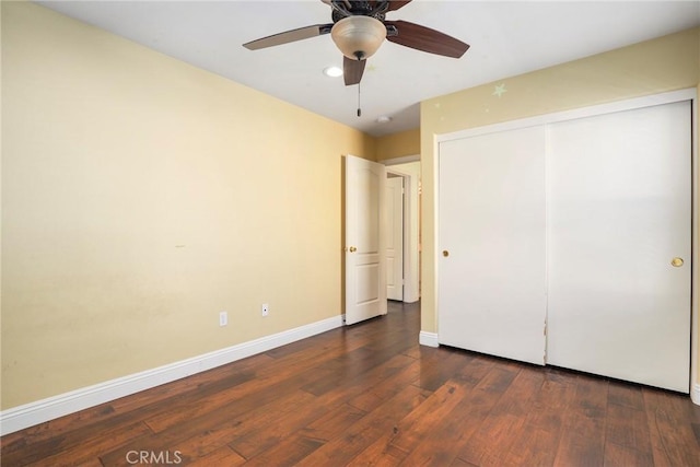 unfurnished bedroom with dark wood-type flooring, ceiling fan, and a closet