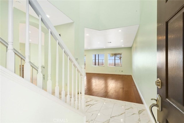 entrance foyer with hardwood / wood-style floors and a high ceiling