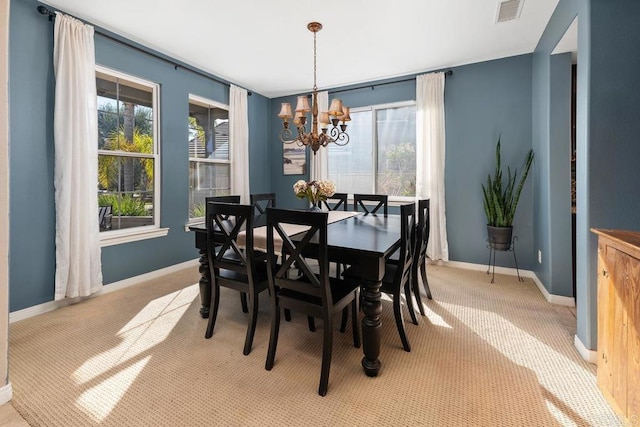 dining space featuring visible vents, light carpet, baseboards, and an inviting chandelier