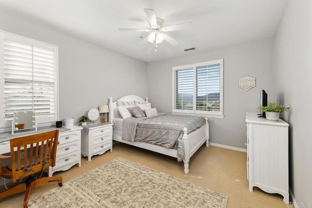 bedroom with baseboards, ceiling fan, visible vents, and light colored carpet