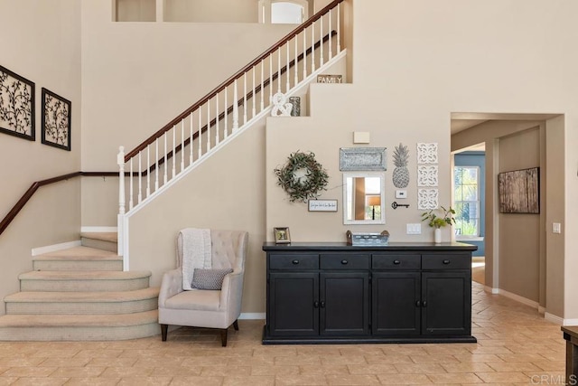 staircase with a towering ceiling and baseboards