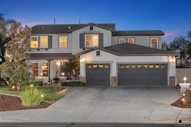 view of front of home with a garage, driveway, stone siding, and stucco siding