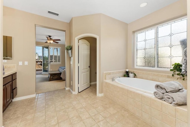 bathroom featuring visible vents, a garden tub, vanity, and baseboards