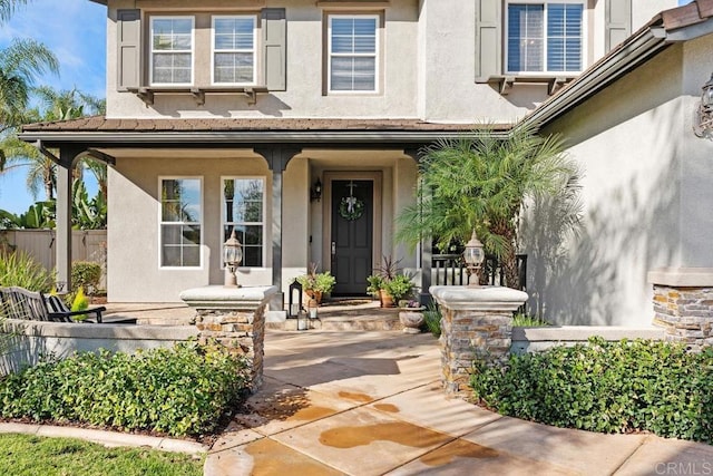 property entrance featuring fence and stucco siding