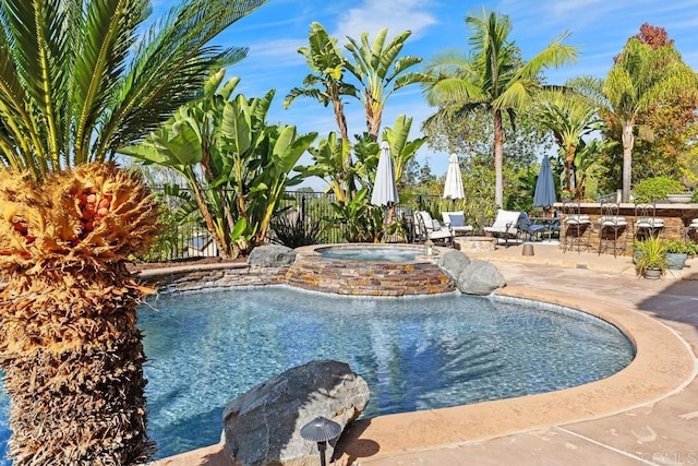 view of pool featuring a fenced in pool, a patio area, fence, an in ground hot tub, and an outdoor bar