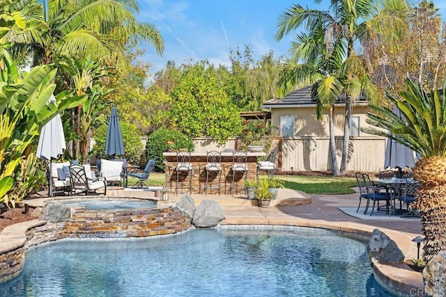 view of pool with fence, outdoor dry bar, and a patio