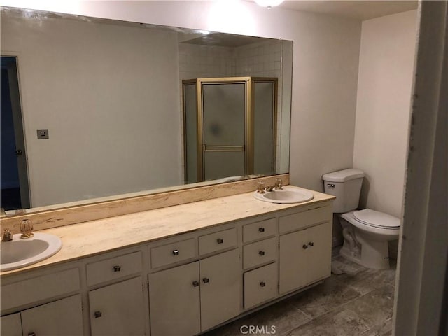 bathroom featuring vanity, toilet, and an enclosed shower