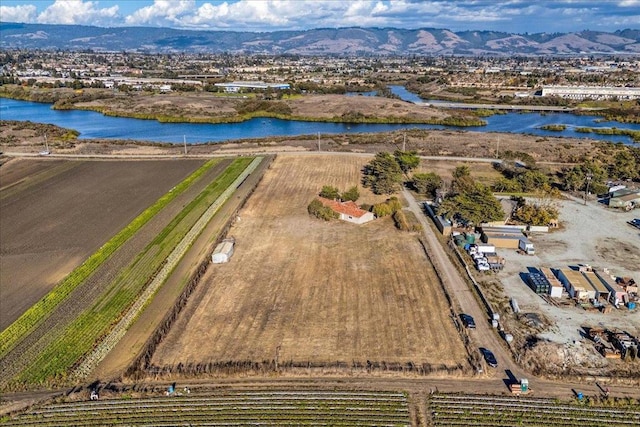 drone / aerial view with a water and mountain view and a rural view