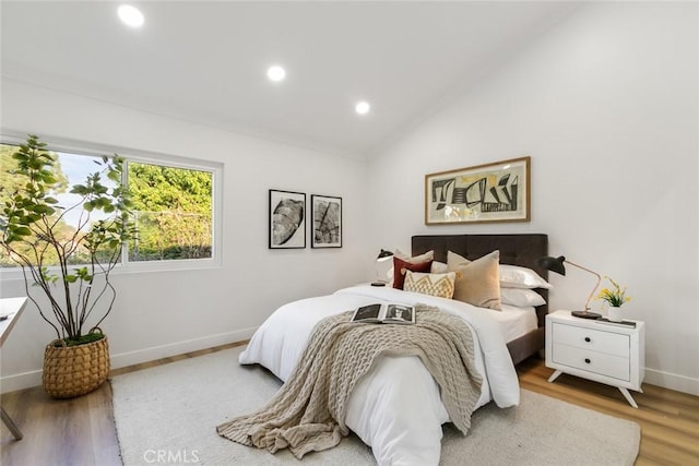 bedroom with wood-type flooring and vaulted ceiling