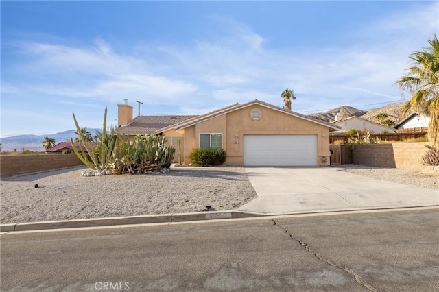 9551 San Rafael Dr, Desert Hot Springs, CA 92240 - single story home featuring an attached garage, driveway, stucco siding, a chimney, and a tile roof
