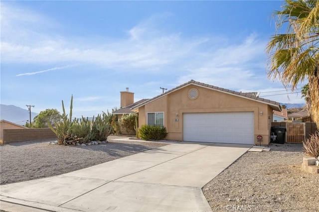 9551 San Rafael Dr, Desert Hot Springs, CA 92240 - ranch-style house featuring driveway, stucco siding, a garage, and a chimney